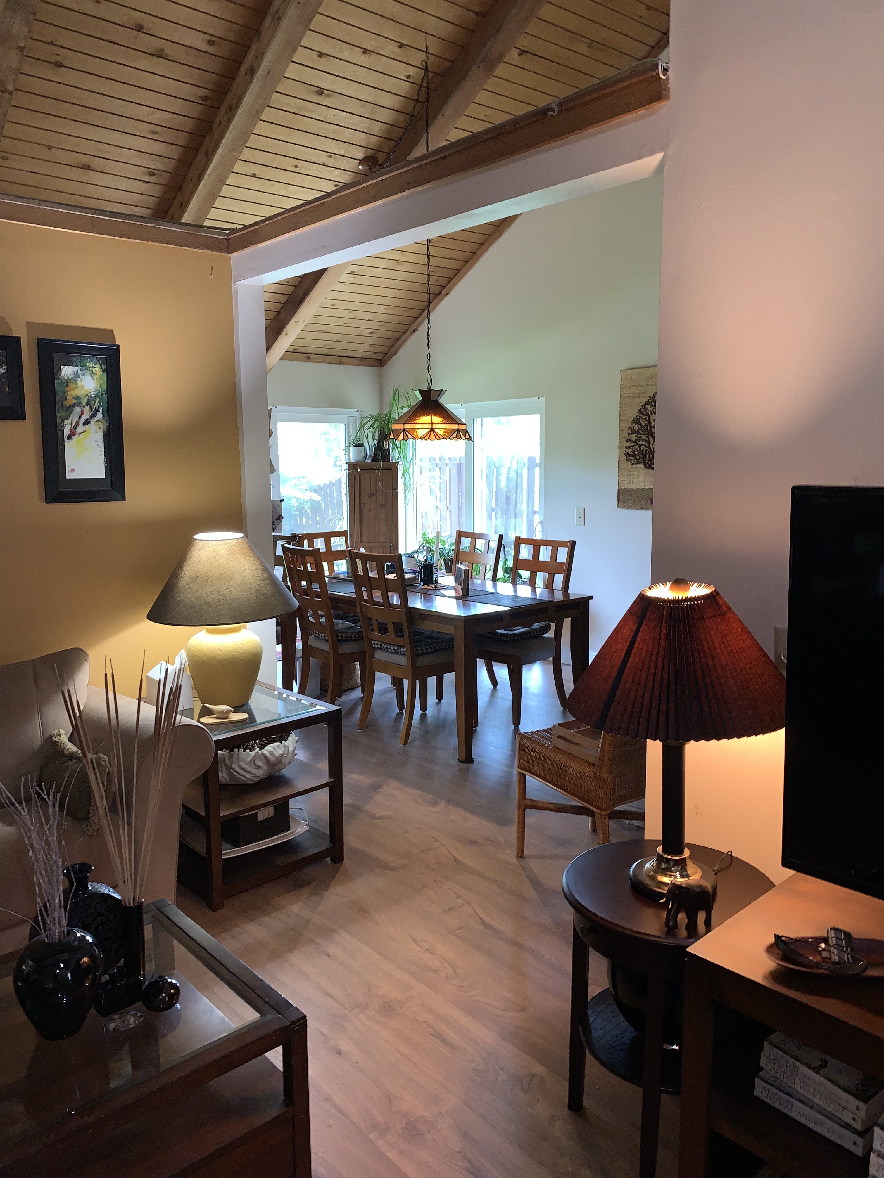 Living and dining spaces beneath vaulted wood ceilings